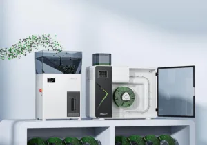 Three Creality 3D printers on a light shelf, with one open showing a green spool inside.