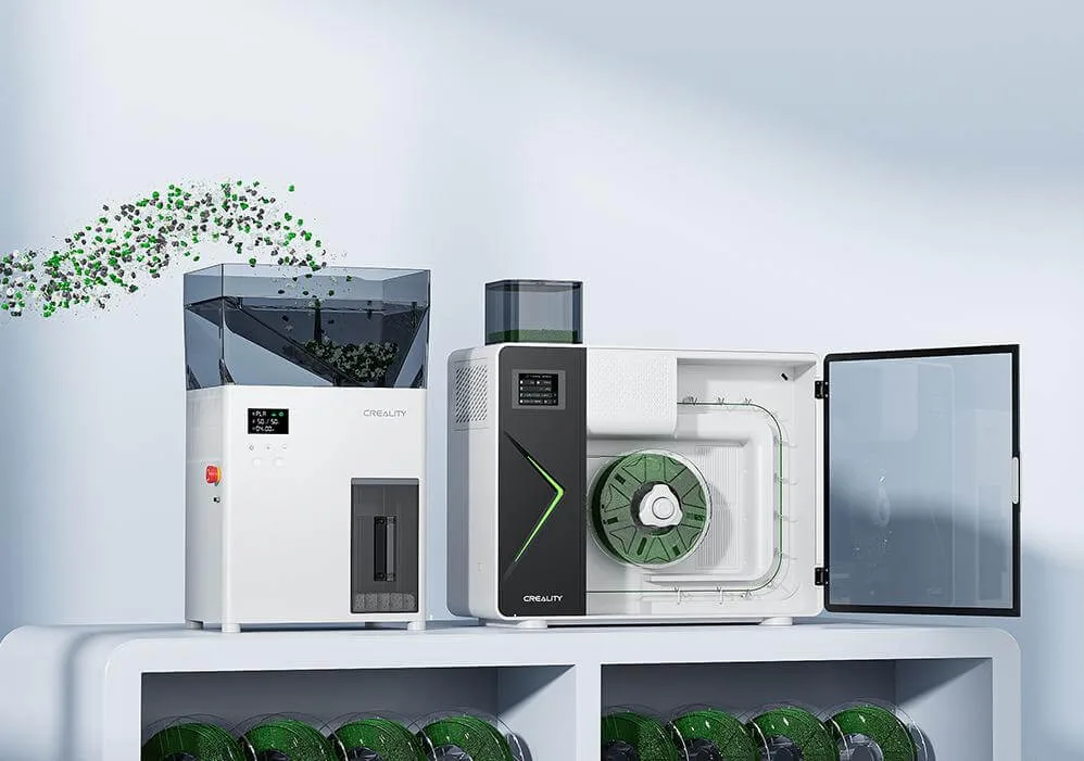 Three Creality 3D printers on a light shelf, with one open showing a green spool inside.