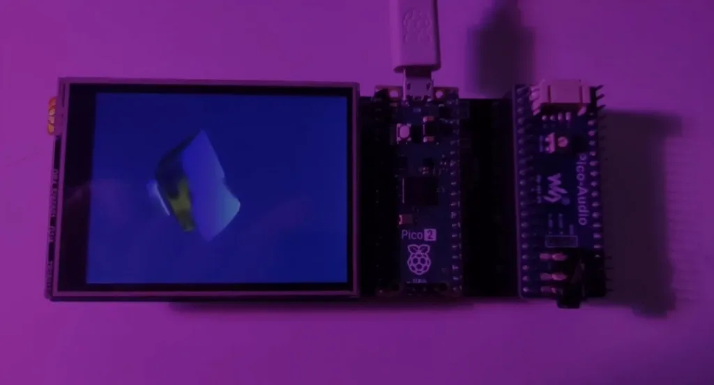Raspberry Pi Pico microcontroller board connected to a small LCD display, photographed in purple lighting with a blue screen showing a vague shape.