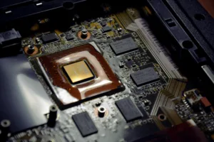 Close-up of a laptop motherboard with a copper heat sink and multiple chips and circuits visible inside the chassis.