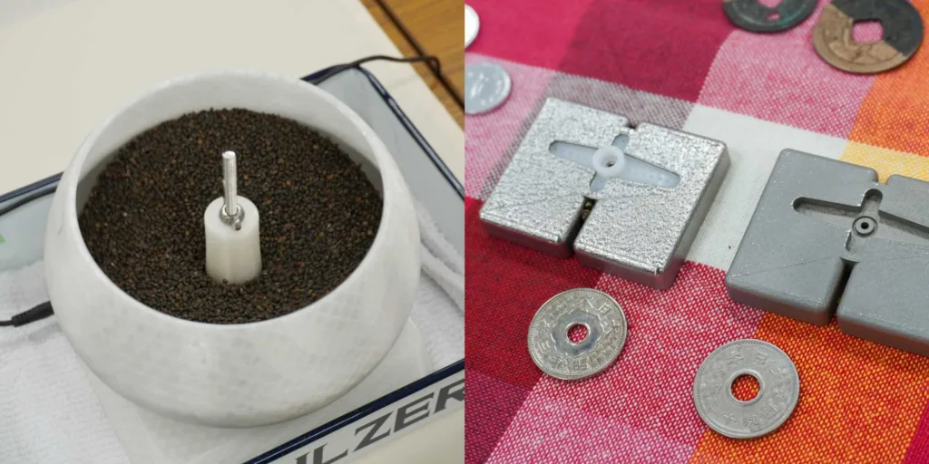 Left: a white coffee grinder with coffee beans inside; right: metal calibration weights and coins on a red checkered cloth
