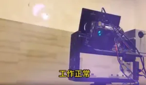 Robotic arm mounted on a metal gantry with exposed wiring, in a workshop or lab, with yellow Chinese subtitles at the bottom of the frame.