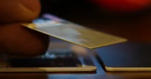 Close-up of a hand inserting a credit card into a payment terminal's slot