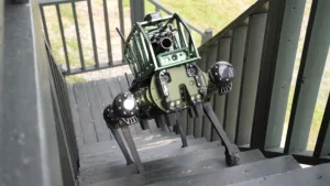 Green robotic camera rig with multiple lenses and sensors mounted on a wooden staircase outdoors.