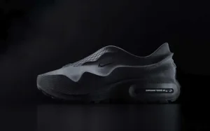 Black Nike running shoe with layered upper and visible air unit in the heel, set on a dark background.