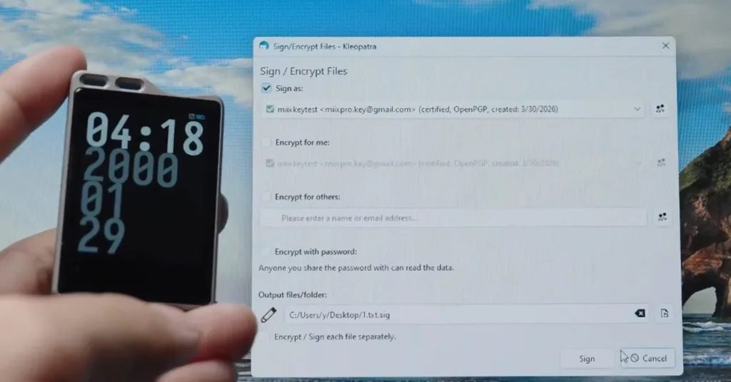 Hand holding a smartphone beside a desktop window titled 'Sign/Encrypt Files' (Kleopatra) showing encryption options on screen
