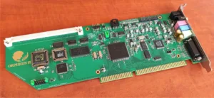Orpheus II circuit board with edge connector, chips, capacitors, and a metal mounting bracket on a wooden surface