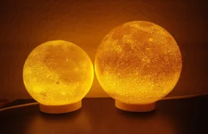 Two round amber lamps glowing warmly on a table, creating a cozy ambiance.