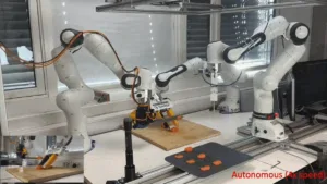 Robotic arms assembly line manipulating orange components on a worktable in a lab, with 'Autonomous (4x speed)' caption in red at bottom right