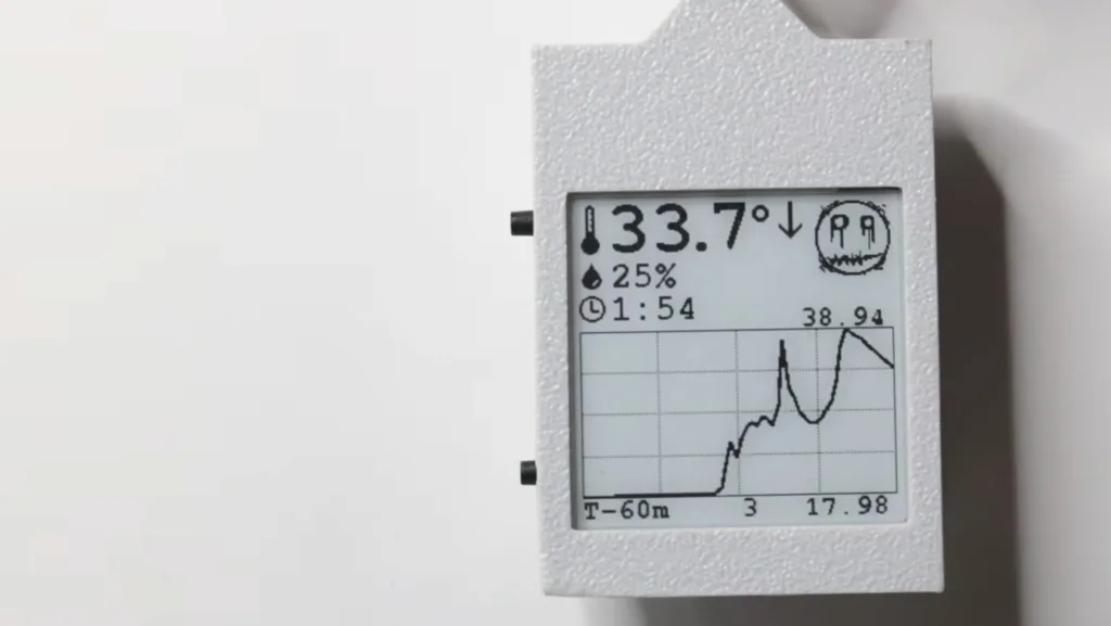 Handheld data logger display showing temperature 33.7°, downward arrow, 25% humidity, and a small graph on the screen.
