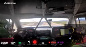 Driver’s-eye view from inside a rally car cockpit showing dashboard telemetry (RPM, speed, throttle, gear, brake, fuel, HR) and a map overlay on the right; Qualcomm logo visible top-left in the dashcam feed.