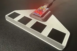 Wing-shaped 3D-printed base with four black solar panels and a USB microcontroller board on top, red LEDs illuminated.