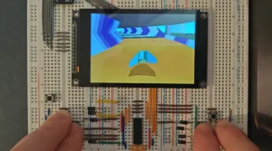 Breadboard with an LCD screen showing a colorful 3D tunnel scene, held by two hands.
