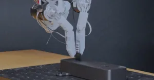 Metal robotic leg prototype mounted on a black testing stand with wires trailing from the joints.