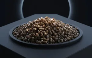 Pile of small brown pellets on a dark plate in a dim setting, with a circular light/arc in the background.