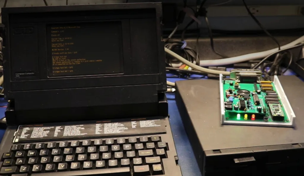Retro computer workstation with a CRT monitor displaying green text and a green circuit board to the right.