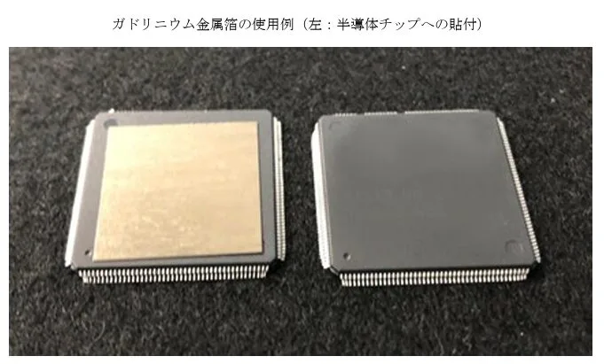 Two square gadolinium metal packages on a dark surface, left one with a semiconductor chip attached, right one bare.