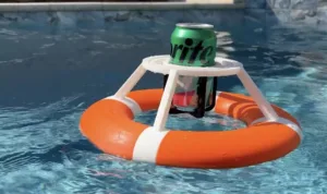 Green Sprite can resting on a small white plastic frame above an orange lifebuoy floating in a swimming pool