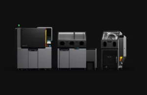 Three large gray industrial printers lined up on a dark background, forming a compact production row.
