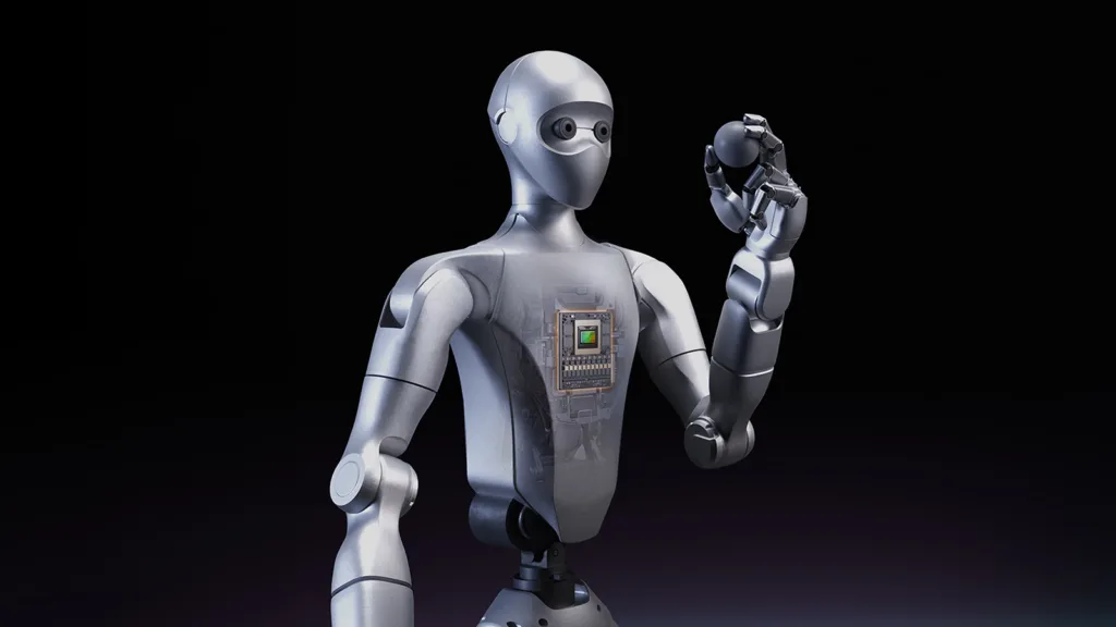 Silver humanoid robot with a transparent chest panel showing internal circuitry, holding a small round ball against a dark background.