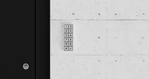 Access keypad with numeric keys 1–9 and 0, plus '#' and backspace, mounted on a concrete wall
